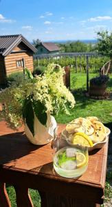 a wooden table with a bowl of food and a vase at Kuća za odmor Mia in Gornja Gračenica