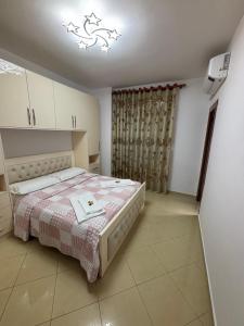 a bedroom with a bed with a pink blanket at Emily House in Fier