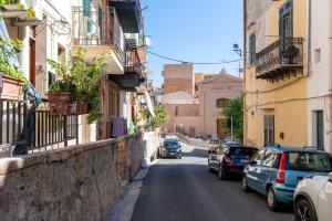 a city street with cars parked on the sides of buildings at Leondoro - Pirandello in Santa Flavia