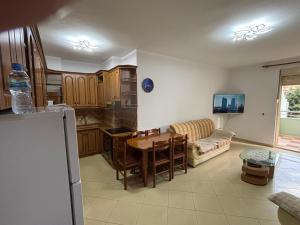 a kitchen and living room with a table and a couch at Emily House in Fier