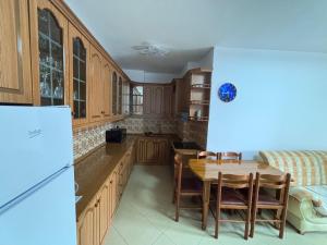 a kitchen with wooden cabinets and a table with chairs at Emily House in Fier +27 photos