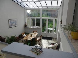 a conservatory with a table and chairs in a room at Roses de Picardie in Chauny