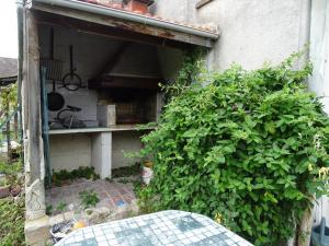 a building with a green hedge next to a kitchen at Roses de Picardie in Chauny
