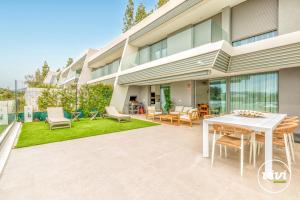 a patio with a white table and chairs in front of a building at ViVi Homes - Marisol Pool, Sauna, Gym, Spa & Beach in Mijas Costa