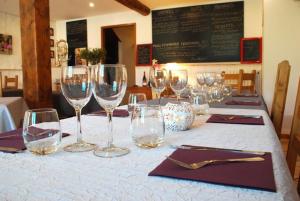 a table with wine glasses on a white table cloth at Auberge le Collet in Saint-Agnan-en-Vercors