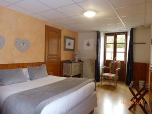 a bedroom with a bed and a desk and a window at Auberge le Collet in Saint-Agnan-en-Vercors