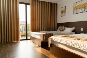 a hotel room with two beds and a balcony at Khách sạn SOLAR HOTEL in Phúc Trì