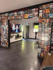 a room with a tv and a wall with video games at Le 7ème Art in Hombourg-Haut