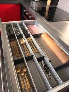 an open drawer with utensils in a kitchen at Le 7ème Art in Hombourg-Haut