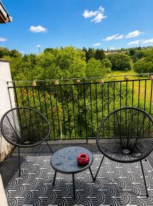 a balcony with two chairs and a table with a red bowl on it at Le 7ème Art in Hombourg-Haut