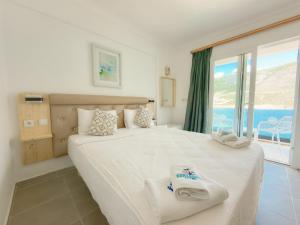 a bedroom with a large bed with a view of the ocean at Korsanada Hotel in Kaş