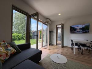 a living room with a couch and a table at Zbilje Lakeside Apartment in Medvode