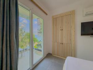 a room with a sliding glass door and a balcony at Korsanada Hotel in Kaş