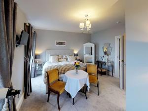 a bedroom with a bed and a table and chairs at Ranscombe House in Brixham