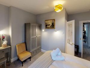 a bedroom with a bed and a chair and a dresser at Ranscombe House in Brixham