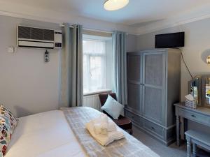 a bedroom with a bed and a desk and a television at Ranscombe House in Brixham
