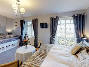 a bedroom with a bed with a table and a window at Ranscombe House in Brixham +10 photos