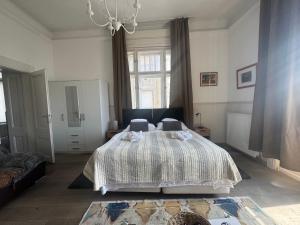a bedroom with a bed and a chandelier at Butterfly Home Danube in Budapest