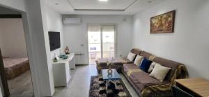 a living room with a couch and a tv at two-bedroom apartment with a living room, kitchen and balcony in Monastir