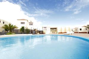 a large swimming pool in front of a house at Casa Be in Caleta De Fuste