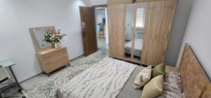 a bedroom with a bed and a dresser and a mirror at two-bedroom apartment with a living room, kitchen and balcony in Monastir