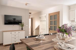 a dining room with a wooden table with wine glasses at JW Apartments in Krościenko