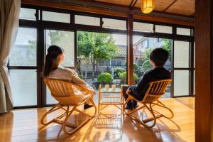 two children sitting in chairs in front of a window at 湯のん - Yunon - 温泉付き一棟貸し古民家 指宿名物 砂むし温泉徒歩2分 最大11名 in Ibusuki +42 photos