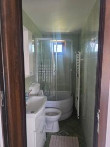 a bathroom with a tub and a toilet and a sink at Mica căsuța in Jurilovca