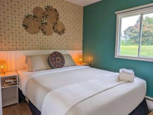 a bedroom with a large white bed and a window at Chalet Studio #3 Waterfront with Spa, Fireplace & Wifi in Cap-Saint-Ignace