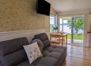 a living room with a couch and a table at Chalet Studio #3 Waterfront with Spa, Fireplace & Wifi in Cap-Saint-Ignace