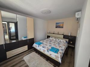 a bedroom with a bed and a large mirror at Mica căsuța in Jurilovca