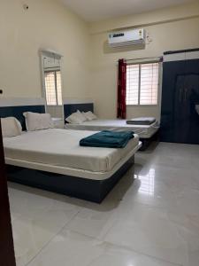 a bedroom with two beds and a air conditioner at Shada Shiv Heritage, Omkareshwar in Godarpura +15 photos