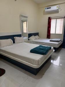 two beds sitting in a room with at Shada Shiv Heritage, Omkareshwar in Godarpura