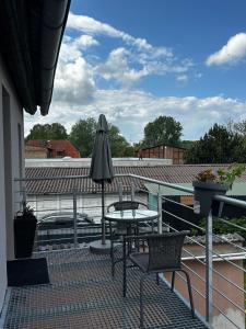 a patio with a table and an umbrella on a roof at Ostsee-Apartment Wolgast in Wolgast
