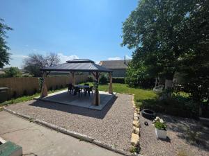 a picnic table under a gazebo in a garden at Mica căsuța in Jurilovca
