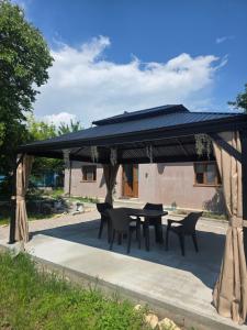 a gazebo with a table and chairs under it at Mica căsuța in Jurilovca