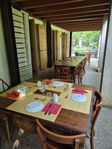 a wooden table with plates and napkins on it at Agribirrificio Corte Petacchi in Volta Mantovana