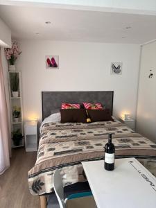 a bedroom with a bed and a table with a bottle of wine at Port nature 2 Villas studio in Cap d'Agde