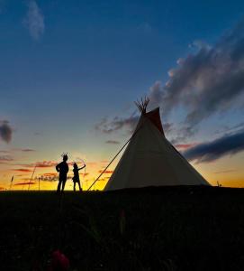 a man and a woman standing next to a tent at Teepee u Vlčího potoka in Jičíněves