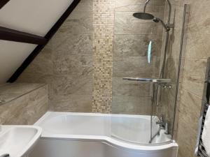 a bathroom with a shower and a tub and a sink at St Nicholas Hotel Shrewsbury in Shrewsbury