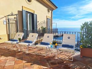 a group of chairs sitting on a patio overlooking the ocean at Odisseo Apartments in Minori
