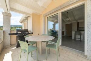 a patio with a table and chairs and a grill at Borgo Myricae in Chia