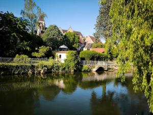 a river with a bridge and a house and a bridge at La Chambres des Secrets in Vierzon