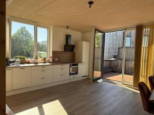 a kitchen with white cabinets and large windows at Ferienhaus Licht-Blick 9 in Wiltingen