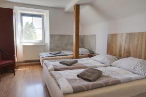 three beds sitting in a room with a window at Ubytovna Statek Olomouc in Olomouc