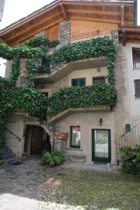 a house with ivy growing on the side of it at Foresteria Traversi in Berbenno di Valtellina