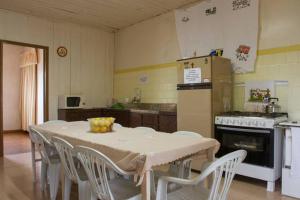 a kitchen with a table and chairs and a kitchen with a stove at Hostel Famiglia Susin in Caxias do Sul