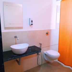 a bathroom with a sink and a toilet at Hotel Marigold Vasad in Vāsad