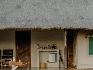 a house with a thatched roof and a kitchen at Butjani Lodge in Cullinan