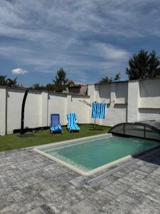 two blue chairs sitting next to a swimming pool at Chalupa Jaroslavice in Jaroslavice